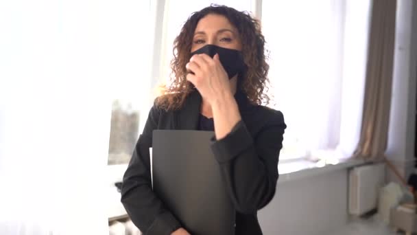 Business woman or teacher in black business suit and mask. Sunny portrait of a curly girl taking off her mask — Wideo stockowe