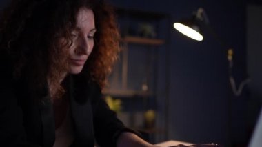 Gece geç saatlerde çalışma masasında, masa lambasının altında üzgün bir kadının portresi. Aşırı çalışma kavramı