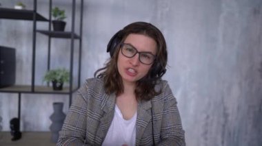POV Young caucasian businesswoman, call center, customer service talking on video call conference or virtual meeting in office, front view, look at camera