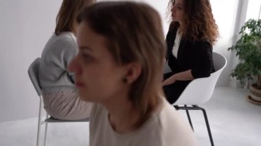 Meeting women in the psychotherapists office. Girls sit in pairs opposite each other and talk in the psychologists office. Womens circle concept, psychological help, mental health