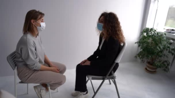 Meeting women in masks in the psychotherapists office during pandemic. Girls sit in pairs opposite each other and talk in the psychologists office. Womens circle concept, psychological help — Stok Video