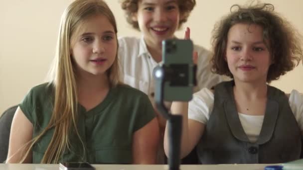 Παιδιά και έφηβοι παρακολουθούν βίντεο και επαναλαμβάνουν χορούς μπροστά σε κάμερα smartphone. Μαθητές και smartphone στην τάξη — Αρχείο Βίντεο