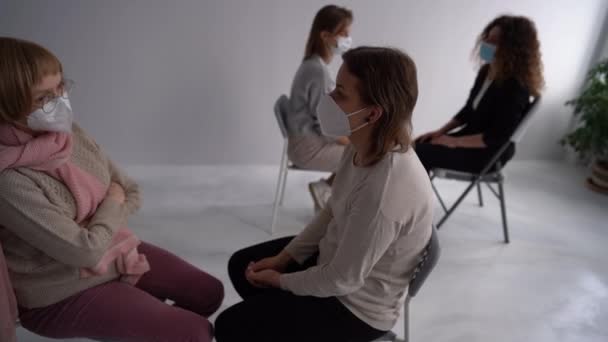 Жінки різного віку в масках зустрічаються в терапевтичній психологічній групі під час пандемії коронавірусу — стокове відео