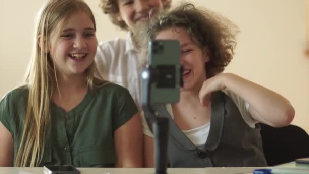 学生为社交媒体拍摄视频趋势。在三脚架上的智能手机摄像机前，青少年们笑着跳舞 — 图库视频影像