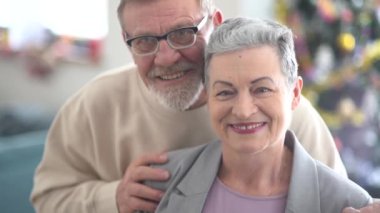 Kameraya bakan yaşlı karı ve kocanın yakın portresi. Şık kısa saçlı bir kadın ve sakallı ve gözlüklü bir adam. Mutlu yaşlılık konsepti