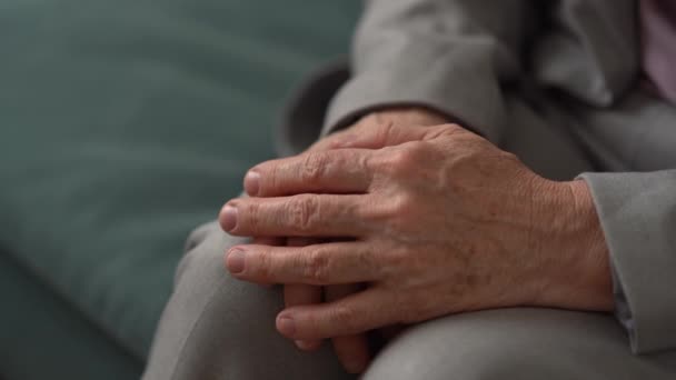 Primer plano de la mano de una anciana irreconocible. Mujer madura dobló sus manos en arrugas y manchas de edad en sus rodillas. Edad avanzada — Vídeos de Stock