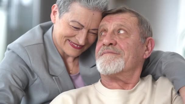 Tenderness and love in the relationship of an elderly gray-haired couple. Woman and man lean their foreheads against each other, portrait of an elderly family — Stock Video