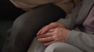 Yaşlı bir adamın elini tutan yaşlı bir kadının eli. Duygusal destek kavramı