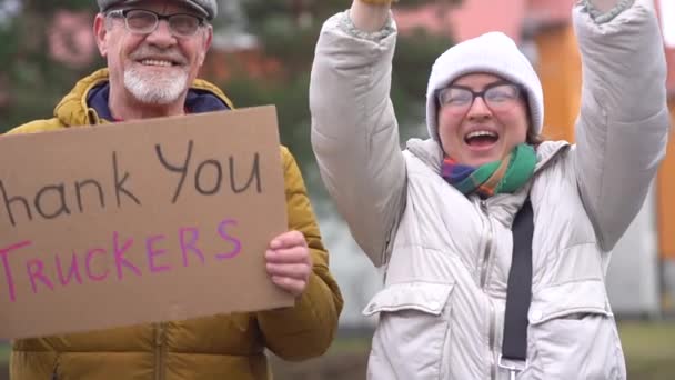 Außenporträt lächelnder Menschen mit Inschriften zur Unterstützung der Anti-Impf-Bewegung in Kanada. Freiheitskonvoi und Trucker-Proteste — Stockvideo