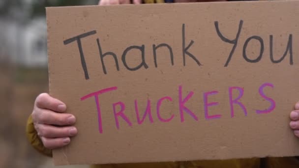 Großaufnahme eines Pappschildes mit der Aufschrift "Danke Trucker" in den Händen eines reifen Mannes. Unterstützung für die Freedom Convoy Movement in Kanada. Friedliche Kundgebung gegen Impfungen, politisches Handeln — Stockvideo