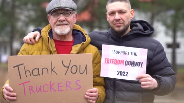 Two men. Portrait of people with posters Thank you truckers and Freedom convoy on every Sunday march against lockdowns and vaccine mandates in a Canada — Stock Video