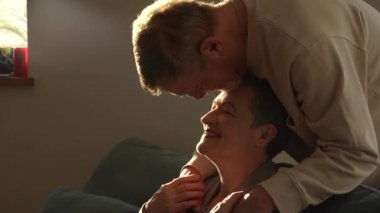 Kameraya bakan yaşlı karı ve kocanın yakın portresi. Şık kısa saçlı bir kadın ve sakallı ve gözlüklü bir adam. Mutlu yaşlı çift Noel 'i kutluyor.