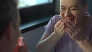 Kanser tedavisi sonrası kemoterapi ya da radyasyonla iyileşen kısa gri saçlı güzel bir kadının portresi. Güçlü kadın aynaya bakar ve güler.