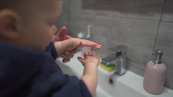 Morfar lär lille sonson att tvätta händerna. Grabben tvättar händerna i badrummet över diskhon. Handhygien under covid-19 — Stockvideo