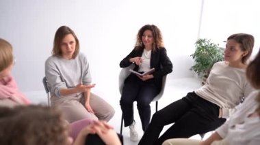 Psikoterapi seansı, grup çalışması, kadın çemberi, psikolojik takımyıldızları. Genç bir kadın grup terapisinde sorunlarından bahsediyor.