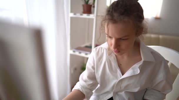 Portrét mladé bělošské umělkyně, která doma omaluje malířskou desku. Atraktivní ženské kreslení obrazu, vytváření uměleckého díla s akvarelem a štětcem vychutnat kreativitu. — Stock video