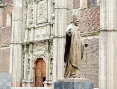 Bronze statue of Pope John Paul monument beside Old basilica in clipart