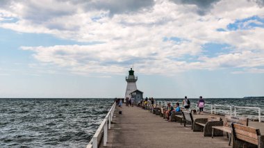 Port Dover, Kanada-3 Ağustos 2021: Kanada 'nın Ontario kentinde Erie Gölü' ndeki Port Dover Batı İskelesi 'ndeki deniz fenerini ziyaret eden insanlar.
