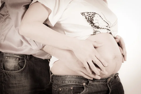 Feliz embarazada y padre manos en forma de corazón en el vientre — Foto de Stock