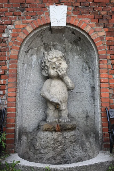 Statua in pietra del tratto nel muro dell'edificio — Foto Stock