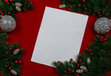 Yeni yıl kartı. Kırmızı arkaplanda yeşil ladin dalları ve süslemeler