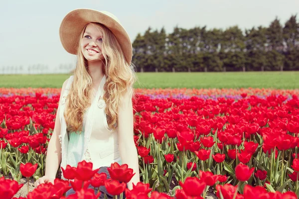 Frau in einem roten Tulpenfeld — Stockfoto