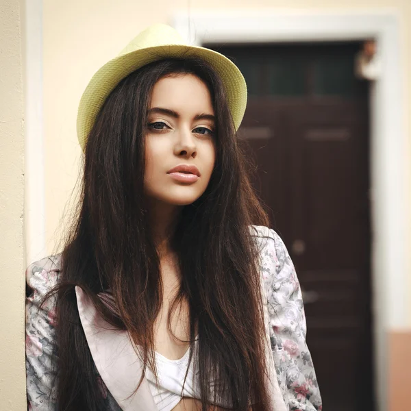 Young beautiful female model standing near the old yellow wall. Cross-process — Stock Photo, Image