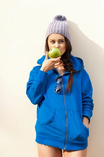 Счастливая молодая женщина ест яблоко — стоковое фото