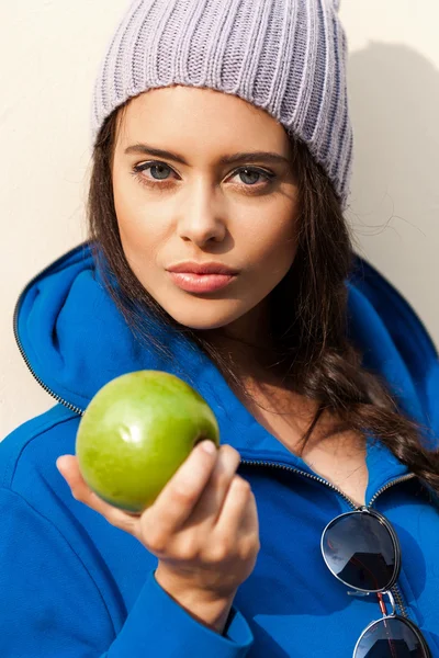 Счастливая молодая женщина ест яблоко — стоковое фото