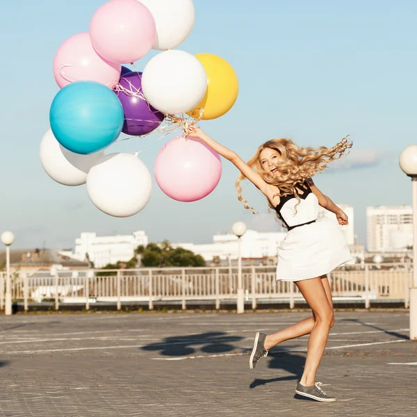 Joyeux jeune femme avec des ballons en latex coloré Image En Vente