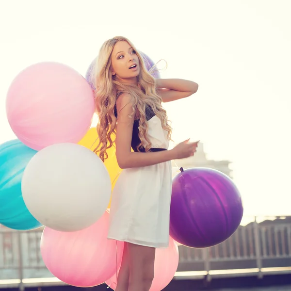 Glückliche junge Frau mit bunten Latexballons — Stockfoto