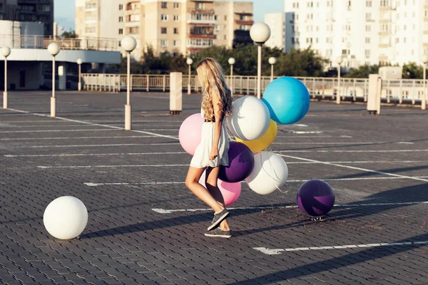 Счастливая молодая женщина с цветными латексными шариками — стоковое фото
