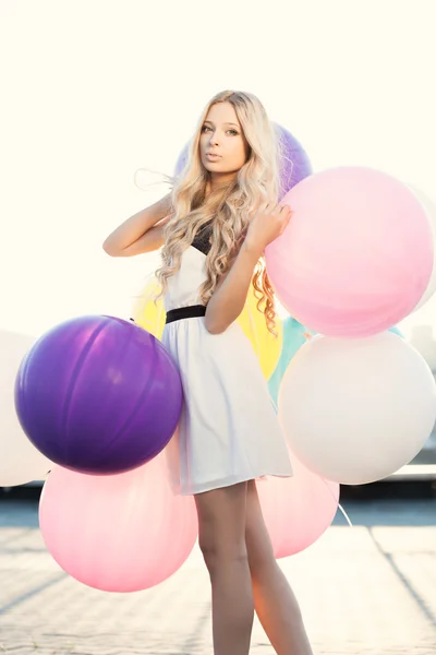 Happy young woman with colorful latex balloons — Stock Photo, Image