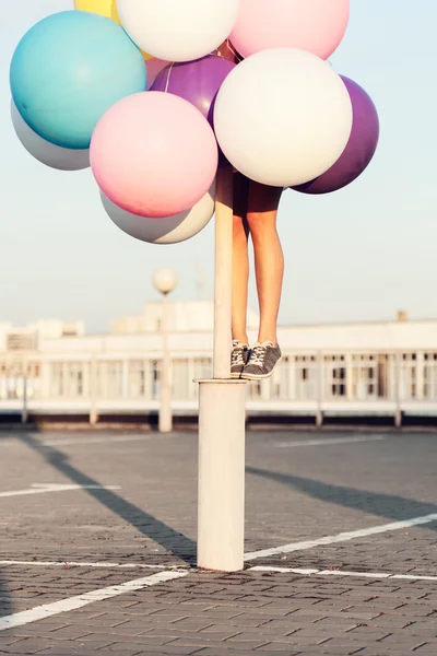 Joyeux jeune femme avec des ballons en latex coloré — Photo
