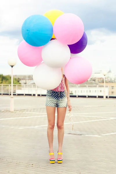 Happy young woman with colorful latex balloons — Stock Photo, Image
