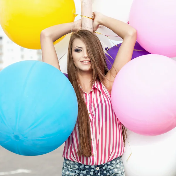 Glückliche junge Frau mit bunten Latexballons — Stockfoto