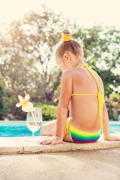 蹒跚学步的女孩，带有热带海滩游泳池的鸡尾酒 — 图库照片