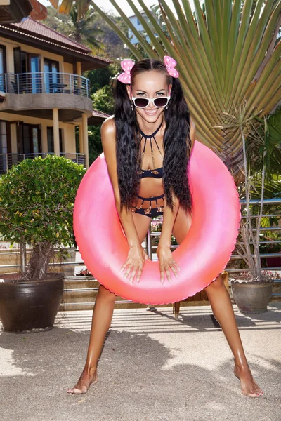 Woman in white sunglasses with pink inner tube — Stock Photo, Image