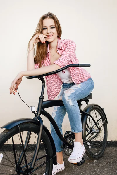 Joven chica hipster con bicicleta negra — Foto de Stock