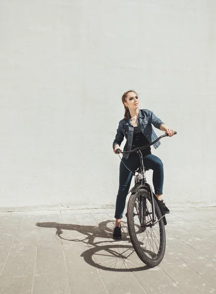 Jovem hipster mulher de pé com bicicleta preta — Fotografia de Stock