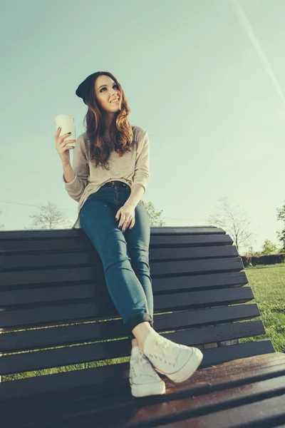 Mooi meisje, zittend op een bankje — Stockfoto