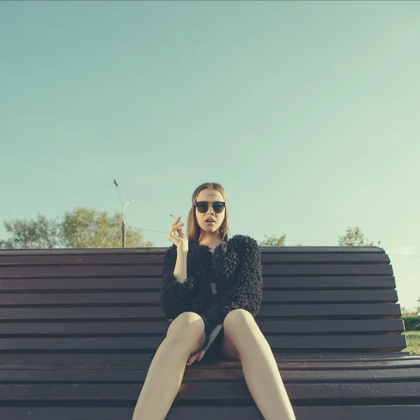 Jonge vrouw rook in park — Stockfoto