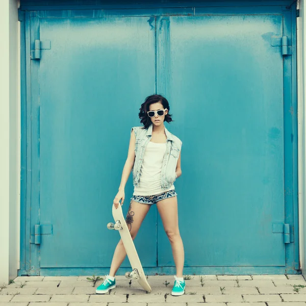 Young brunette woman posing with skateboard — Stock Photo, Image