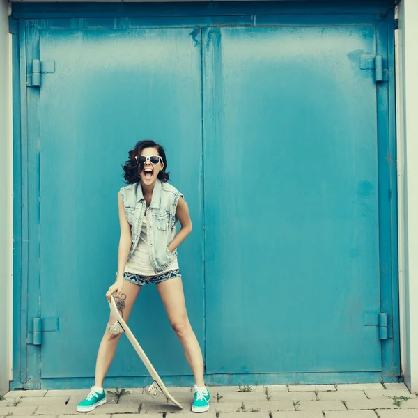 Young brunette woman posing with skateboard — Stock Photo, Image