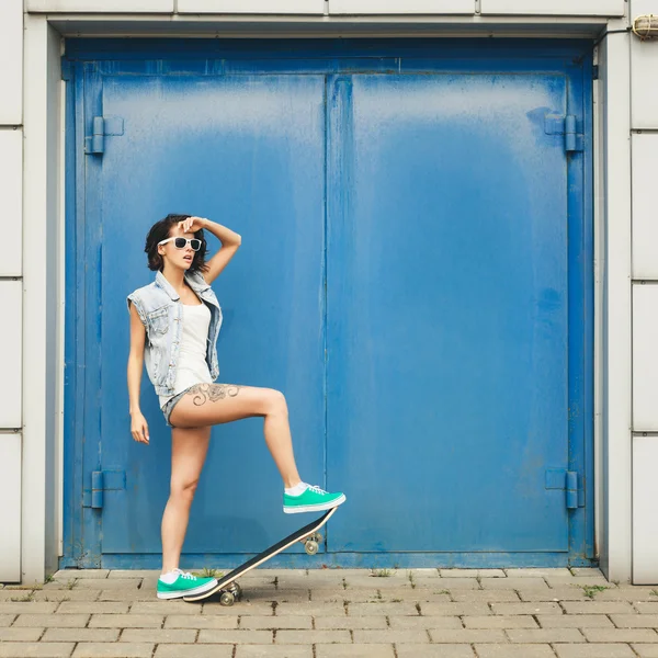 Young brunette woman posing with skateboard — Stock Photo, Image