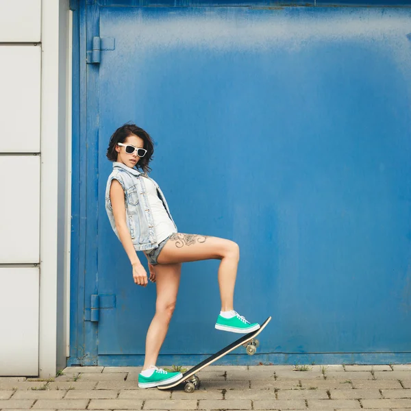 年轻的黑发女人，与滑板合影 — 图库照片
