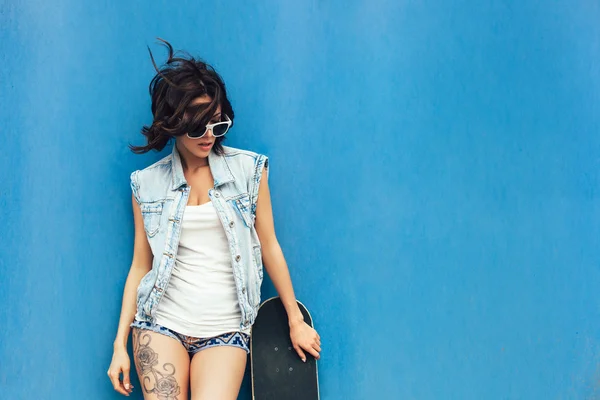 Young brunette woman posing with skateboard — Stock Photo, Image