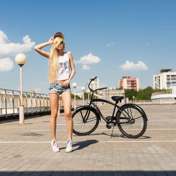 Bela jovem mulher com bicicleta ao ar livre — Fotografia de Stock