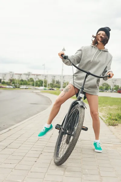 Menina jovem hipster com bicicleta preta — Fotografia de Stock