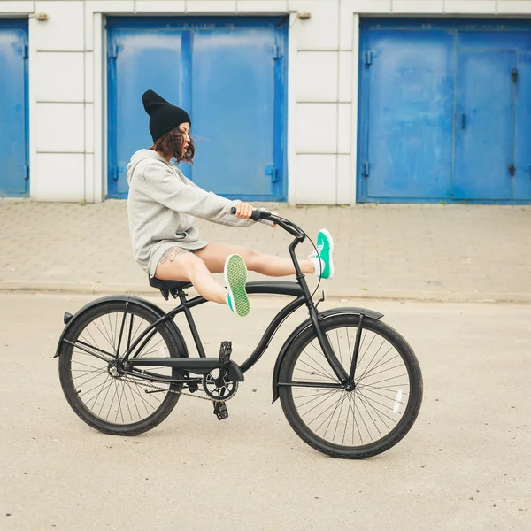 Unga hipster tjej med svart cykel — Stockfoto